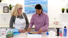 two women in aprons working on an art project