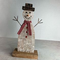 a snowman made out of burlap and wood with a hat on it's head