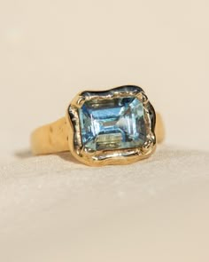 La Vague - translating to the wave embodies the ebb and flow of the oceanic nature of the tides of life, imparting the wisdom and conscious awareness to face our challenges with courage and encouragement. One of a kind hand-carved 14k Yellow gold ring featuring a stunning emerald cut Aquamarine. Stone measures approx. 2.1ct. 9x7mm. *Limited Availability! Only a few of these beauties available - stone color and inclusions will vary slightly. 💌 Please write desired size (between 4-8) in *Notes* s Blue Diamond Engagement Rings, Wavy Engagement Ring, Capri Wedding, Emerald Cut Ring, Conscious Awareness, Ebb And Flow, Fine Jewelery, Ocean Jewelry, Blue Stone Ring