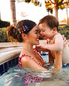 a woman holding a baby in a swimming pool