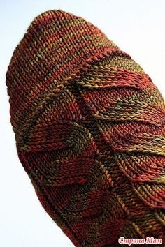 a close up view of a knitted hat on a white background with red, green and yellow colors