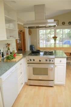 a kitchen with an oven, stove and counter tops in the center of the room