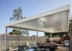 a covered patio with furniture and an outdoor kitchen