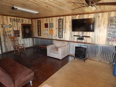 a living room filled with furniture and a flat screen tv mounted to the side of a wall