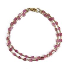 This bracelet combines 3mm pink tourmaline cube beads with sleek yellow gold-filled tube spacers for a touch of modern luxury. The minimalist design makes it a versatile piece that goes with anything, adding a pop of color and a touch of geometric edge to your everyday style. Handcrafted for a unique feel. The bracelet is strung on sturdy beading wire and features a secure lobster clasp for a comfortable fit. It measures approximately 7.5 inches long, making it perfect for everyday wear. Love pink? Love minimalist style? This bracelet is for you! *  Genuine and all Natural 3mm Pink Tourmaline Cube Beads *  Yellow Gold-Filled Tube Bead Spacers, Lobster Clasp and Ring *  7.5" Long Measured End to End *  Strung on a Poly Coated Beading Wire * Artisan made in Texas, USA *  Thoughtfully Package Luxury Modern Beaded Bracelets For Everyday, Luxury Modern Everyday Beaded Bracelets, Luxury Yellow Gold Beaded Bracelets With Gemstones, Luxury Pink Jewelry With Colorful Beads, Luxury Yellow Gold Beaded Bracelet With Gemstones, Modern Pink Gold Luxury Bracelets, Modern Luxury Pink Gold Bracelets, Luxury Pink Gemstone Bracelets, Luxury Pink Jewelry With Gemstone Beads