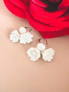 Skillfully crafted by hand, each earring showcases two delicate white clay flowers adorned with freshwater pearls. These exquisitely made flower bridal earrings are a perfect choice for your special day. 🖤 M A T E R I A L S  *  A N D  *  S I Z E  🖤 ❇️ MATERIAL & METAL: Brass- Clay Flower/Freshwater Pearl/Cubic Zirconia ❇️ METAL PLATING: Silver/Gold/Rose Gold ❇️ ESTIMATED SIZE: 3cm Length (Included Finish Post) ❇️ ESTIMATED WEIGHT: 8gram ❇️ QUANTITY: 1pair ❇️ LEAD-FREE & NICKEL FREE 🖤 A V A I L A B L E  *  F I N I S H 🖤 ❇️#1-CZ HOOP ❇️#2-CRYSTAL POST ❇️#3-PLAIN FISH HOOK ❇️#4-TEXTURE FISH HOOK ❇️#5-CLIP ON ❇️#6-PLAIN HOOP ❇️#7-CZ FISH HOOK ❇️#8-CZ FISH HOOK 🖤 C U S T O M I Z I N G  *  A N  *  E X I S T I N G  *  P I E C E 🖤 If you love this piece but feel you would like to make a few Clay Flower Jewelry, Clay Flower, Clay Flowers, Flower Jewelry, White Clay, Jewelry Wedding, Boho Floral, Flower Jewellery, White Flower