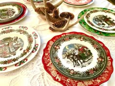 a table topped with plates covered in christmas themed designs and pineconi cones on top of it