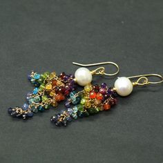 "Rainbow Gemstone and Pearl Earrings in Gold Fold 17 different gemstone types and dozens or gemston beads - each bead has been individually wire wrapped onto a gold filled headpin, and chain. The cluster is topped with lustrous, large Pearl. Gorgeous cascades of a rainbow color gems are highlighted by the contrast of the large pearls. The beautiful and shiny pearls give the earrings a classic and elegant look These are natural, not colourd excellent AAA quality gems beautifuly faceted and shimme Elegant Multicolor Gemstone Chandelier Earrings, Handmade Elegant Rainbow Earrings, Elegant Handmade Rainbow Earrings, Elegant Rainbow Dangle Jewelry, Handmade Elegant Rainbow Gemstones, Elegant Multicolor Dangle Pearl Earrings, Elegant Handmade Rainbow Gemstones, Elegant Multicolor Teardrop Gemstones, Multicolor Long Drop Gemstone Earrings