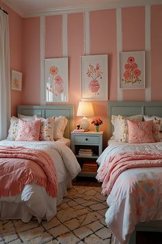 two beds in a bedroom with pink and white walls