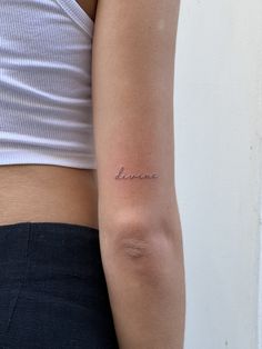 a woman's arm with the word love tattooed on her left arm, in cursive font