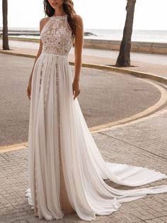 a woman in a white dress standing on the street