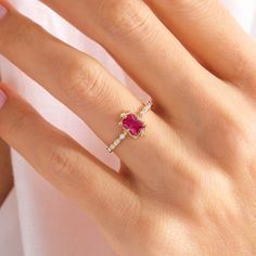 a woman's hand with a ring on it and a pink diamond in the middle