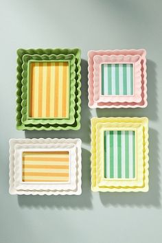 three small trays that have different designs on them, one is yellow and the other is green