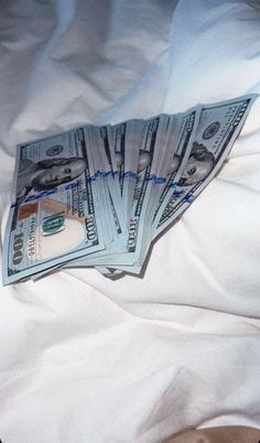 a pile of money sitting on top of a bed