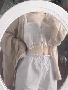 a mannequin wearing white shorts and a cropped top in front of a mirror