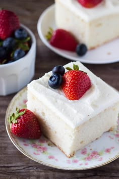 there is a piece of cake with berries on top and another slice has blueberries