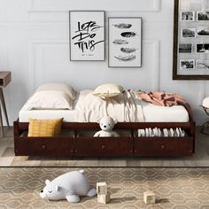 a bed with two drawers and a stuffed animal on the floor