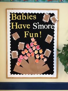 there is a sign that says babies have smore fun on the wall next to a potted plant