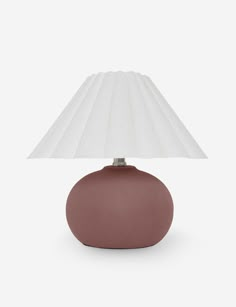 a small table lamp with a white shade on the top and a brown base, against a white background