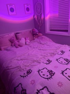 a bedroom with hello kitty bedding and purple lighting in the corner, along with stuffed animals