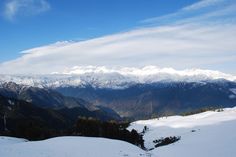 the mountains are covered in snow and clouds