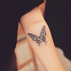 a small butterfly tattoo on the right forearm and arm, with an arrow in the middle