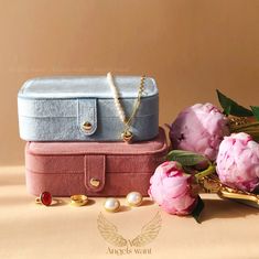 three pieces of jewelry sitting on top of each other next to pink flowers and leaves