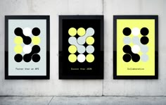 three black and yellow posters on the wall with white circles in them, each one has an individual's own name