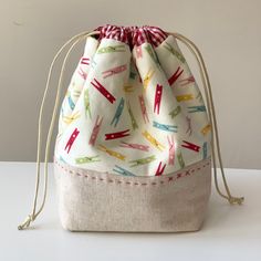 a drawstring bag with different colored arrows on the front and bottom, sitting on a white surface