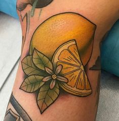 a close up of a person's leg with a tattoo on it and an orange