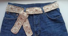 a pair of jeans with a crocheted belt on it's back pocket