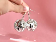 Some fun disco ball earrings, sure to be a showstopper! Super fun for bachelorette parties, music festivals, and roller rinks too. Thanks for takin' a look, if you have any questions just lemme know! If you plan on ordering more than 10 message me and I'll give you a discount code :) 🌼Earring: Silver Hook  🌼Charm: Disco Ball 🌼Size: Full length measures 2 inches  🌼 Color: Silver 🌼These earrings a premade and ready to ship immediately :) If you have a custom request, lemme know! I'd love to w Disco Style Silver Jewelry For Party, Adjustable Pierced Earrings For Parties, Nickel Free Novelty Earrings For Party, Novelty Drop Earrings For Party, Adjustable Metal Plug Earrings For Party, Nickel-free Round Earrings For Party, Handmade Metal Plug Earrings For Party, Nickel Free Round Earrings For Party, Handmade Party Plug Earrings