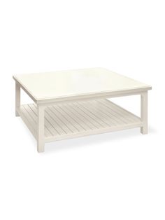 a white coffee table sitting on top of a wooden shelf