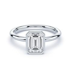 an emerald - cut diamond ring with a thin band on the side, set in 18k white gold