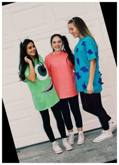 three girls in costumes standing next to a garage door