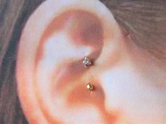 a woman's ear is shown with two small diamond studs on the side