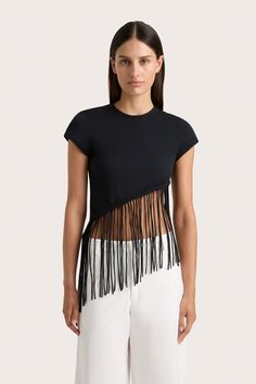 A fitted 100% cotton jersey tee with a high-cut neckline, cropping just above the waist. It features handwoven macrame detailing and fringe, falling diagonally across the torso. Style with the Cassis Pant for an effortless everyday. Fringe Tee Shirt, Cut Up Tees, Upcycle Inspiration, Cut Up T Shirt, Fringe Tshirt, Spiritual Fashion, Slim Fit Crop Top, Cut Shirt, Cut T Shirt