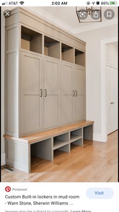 an empty room with some wooden shelves and drawers on the wall next to a light fixture