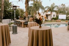 an outdoor party with tables and chairs near a pool