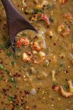 a wooden spoon sitting in a bowl filled with soup