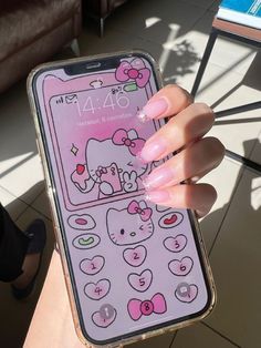 a person holding a cell phone with hello kitty on it