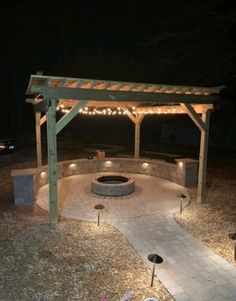 an outdoor fire pit with lights around it