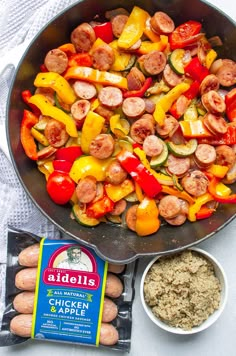 a pan filled with sausages, peppers and other ingredients next to a bag of rice