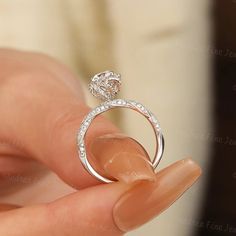 a person holding a diamond ring in their hand