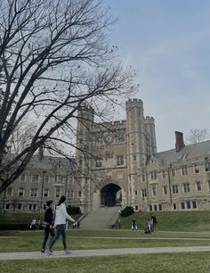 two people walking in front of a large building