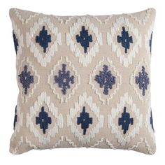 an embroidered pillow with blue and white designs on the front, sitting on a white background