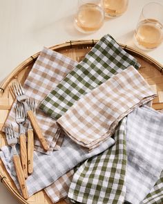 napkins and forks are laid out on a wicker tray