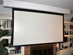 a large screen mounted to the wall above a fireplace