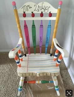 a child's wooden rocking chair made out of crayons and pencils