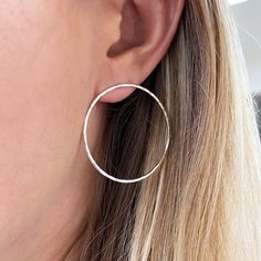 These oversize silver hoop studs make a beautiful statement piece, that are lightweight enough to be worn every day. The circle studs are finished with a hammered texture that reflects the light beautifully. Each sterling silver earring is polished to a high finish for a minimalist look.  The O studs measure 40mm diameter (1 1/2 inches), made from 1.5mm sterling silver. They have sterling silver marked 925 butterfly push backs. The hammered earrings will be delivered in a recycled, branded gift ready for gift giving. Nickel Free Circular Earrings, Silver Single Circular Earring, Silver Single Open Circle Earring, Single Silver Open Circle Earring, Silver Minimalist Hoop Plug Earrings, Minimalist Silver Hoop Plug Earrings, Silver Open Circle Earrings For Pierced Ears, Silver Hammered Open Circle Earrings, Silver Plug Earrings For Anniversary